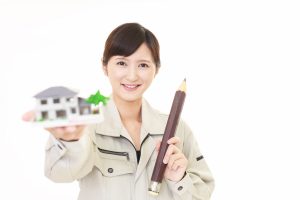 鉛筆と住宅模型を持つ女子作業員