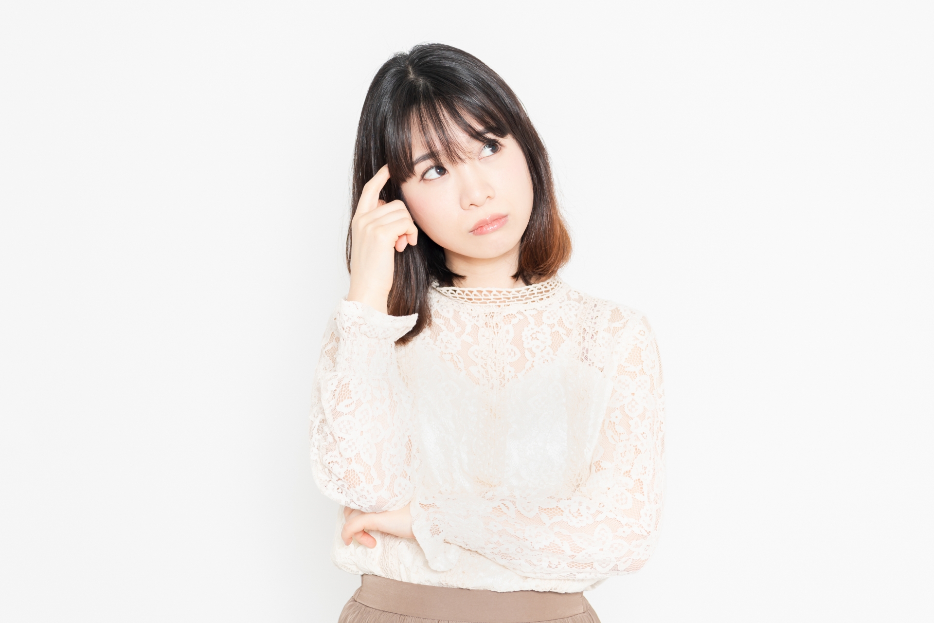 悩んでいるレースのブラウスを着た若い女性