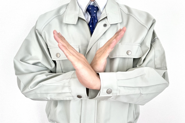 手でバツをする男性