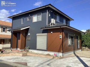 ネイビーブルーとブラウンのツートンデザインの住宅