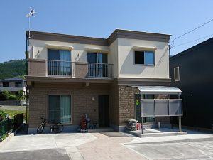 クリーム色とブラウンのツートン外壁の住宅