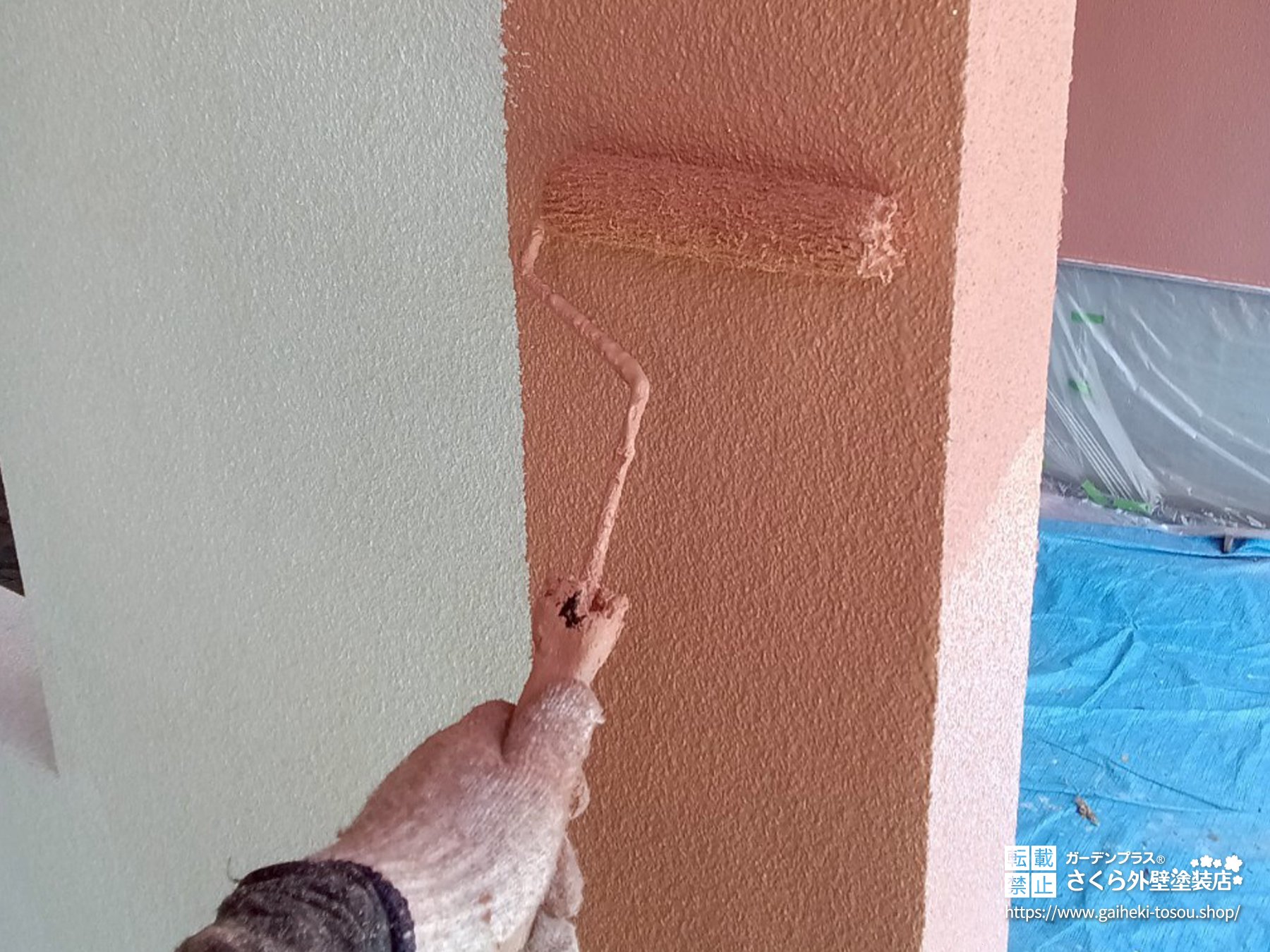 職人がモルタル外壁を塗装している様子