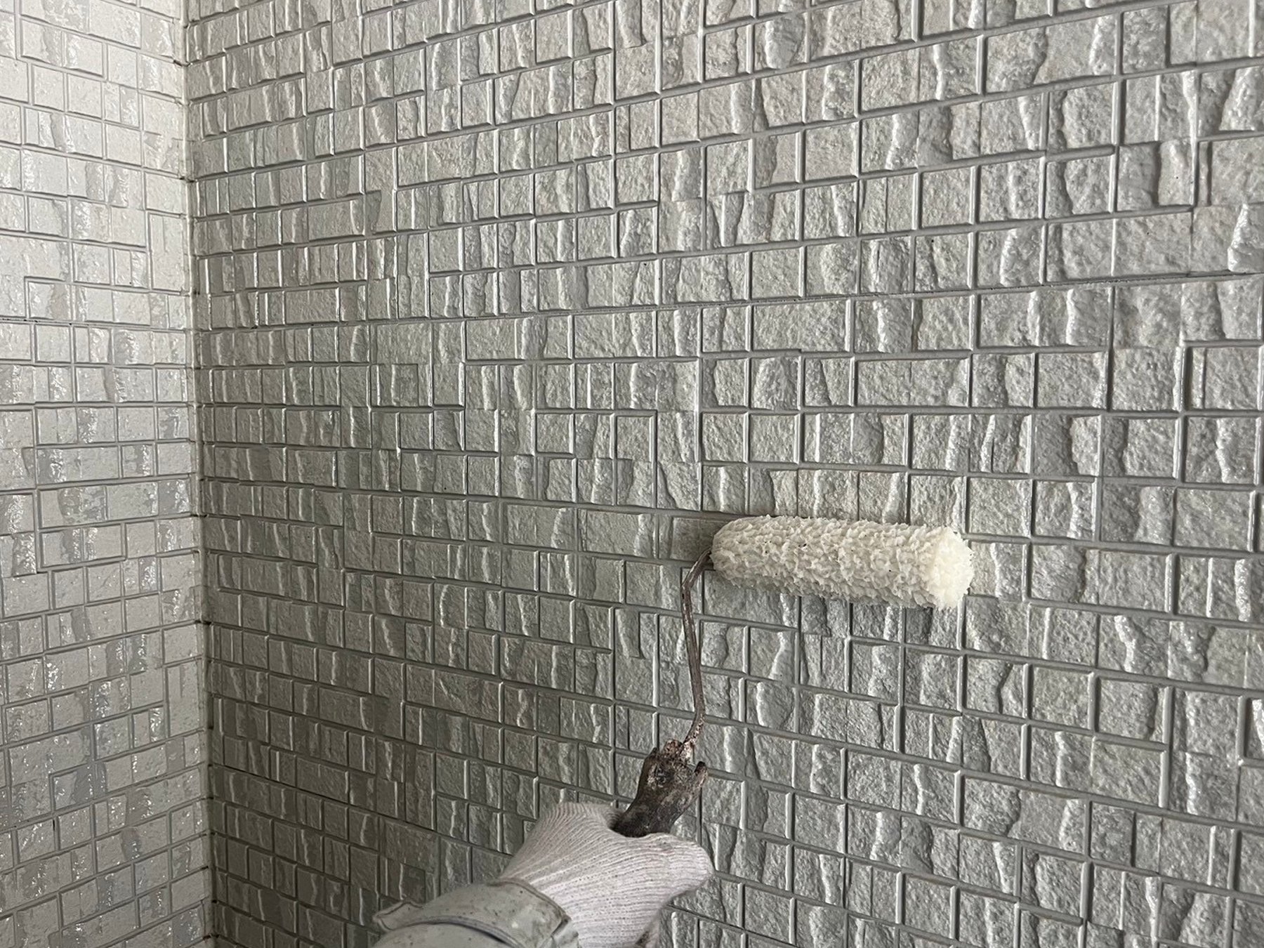 外壁塗装をする職人の手