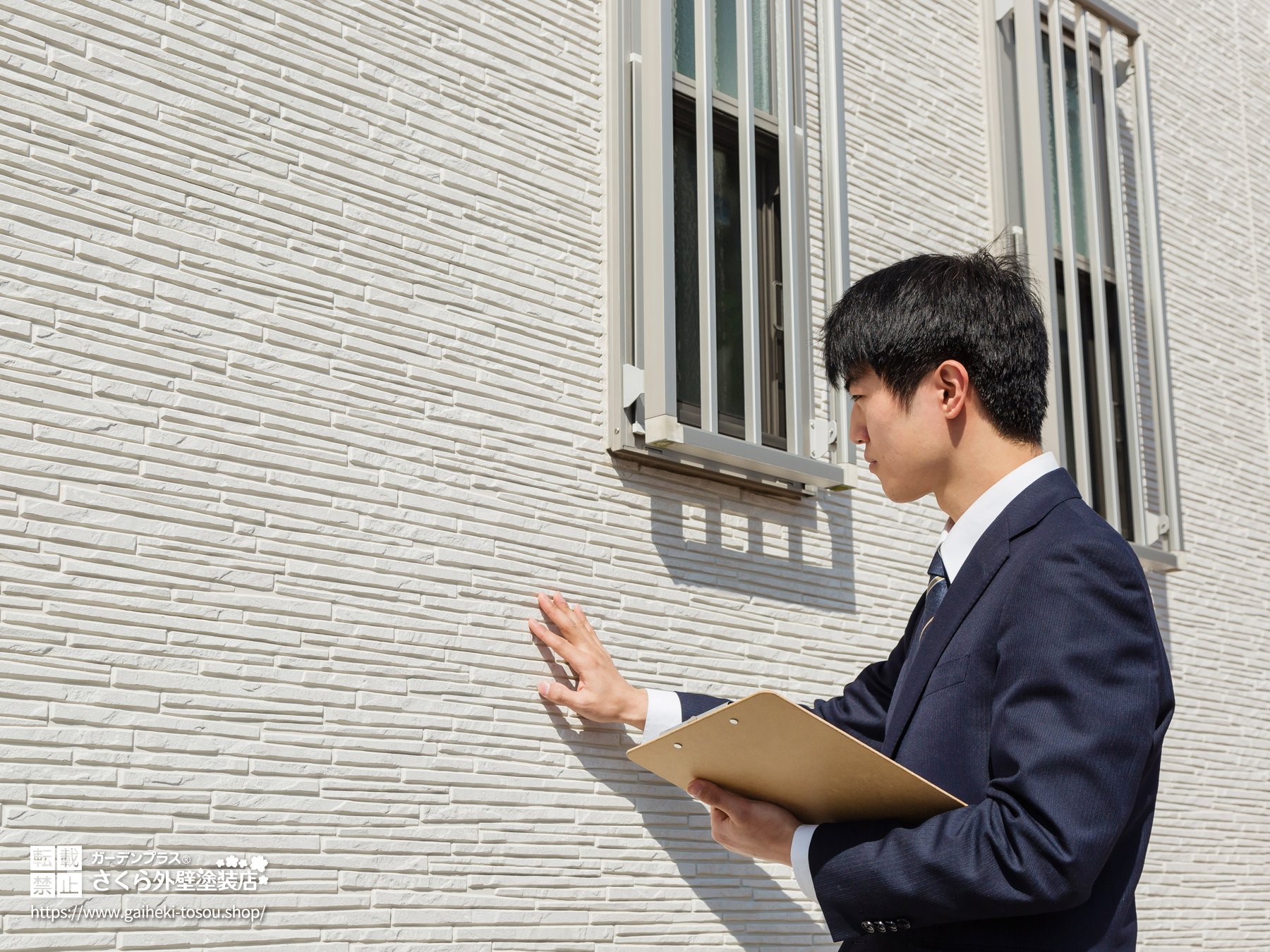 外壁をチェックする外壁塗装業者
