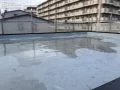 屋上の陸屋根の防水塗装工事～下塗り～ 汚れや廃棄物を除去後、下塗りをしていきます。[下塗り途中の陸屋根全体の様子]