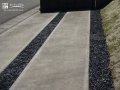 轍のコンクリートとのコントラストが美しい黒砂利の駐車スペース施工